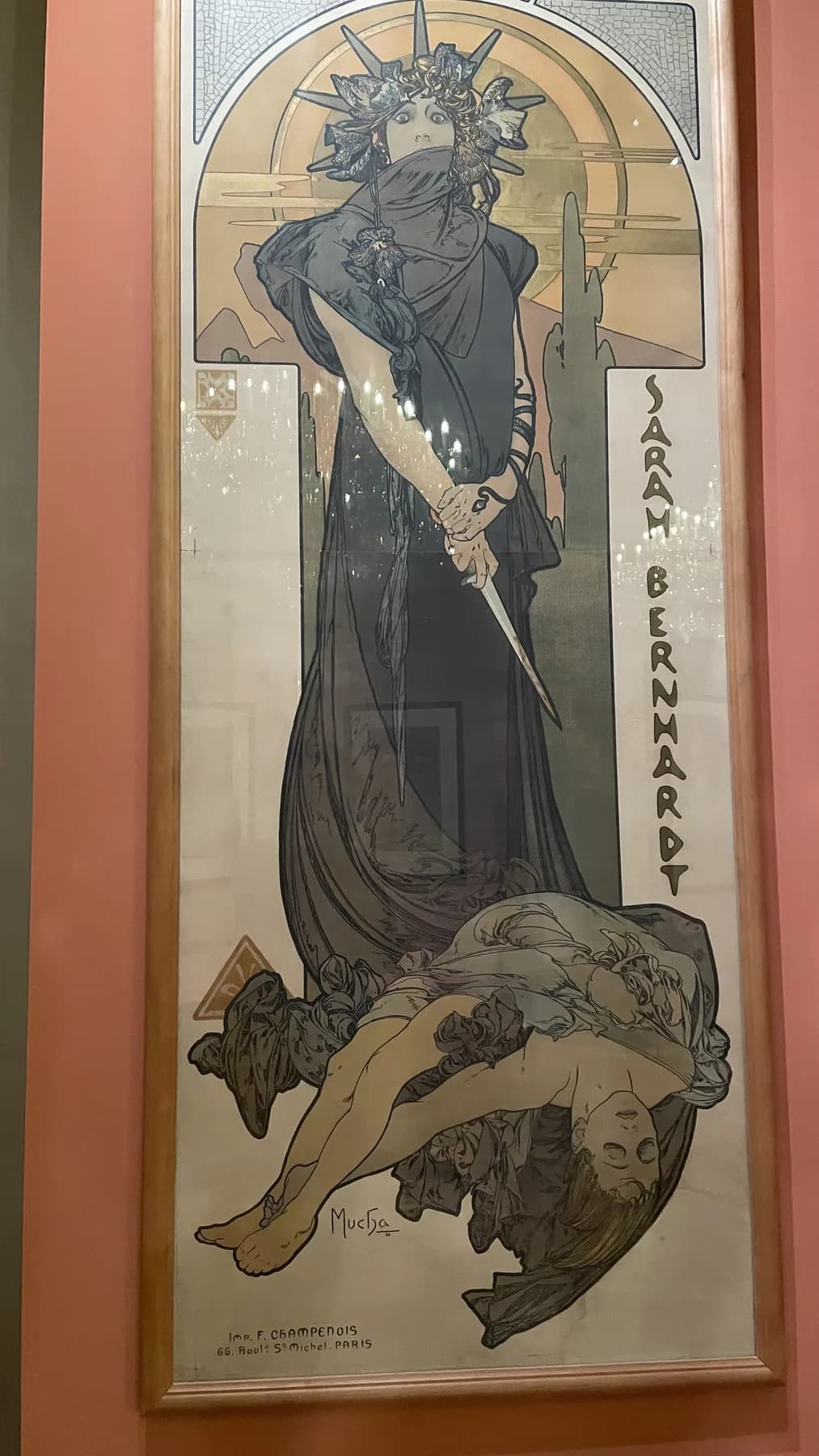 A tall Sarah Bernhardt theatre poster by Alphonse Mucha, showing a central figure, circular halo, vertical type, and ornamental borders.